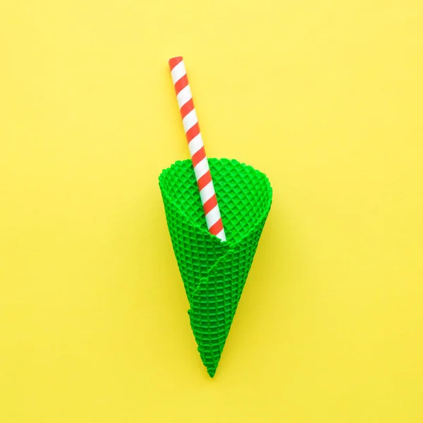 Mléčný koktejl abstraktní ze zeleného kornoutu zmrzliny a červené pitné slámy na žluté. — Stock fotografie