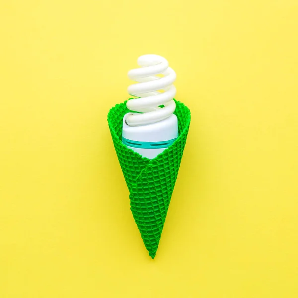 Energiatakarékos izzó fagylalt kúp elvont sárga. — Stock Fotó