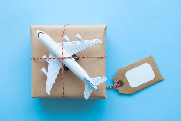 Κουτί παράδοσης χαρτονιού με ετικέτα copy space και αφηρημένο μικρό αεροπλάνο σε μπλε. — Φωτογραφία Αρχείου