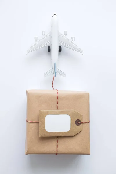 Κουτί παράδοσης χαρτονιού με ετικέτα copy space και αφηρημένο μικρό αεροπλάνο σε λευκό. — Φωτογραφία Αρχείου