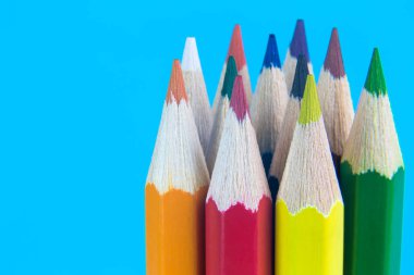 Close up of color pencils back to school supplies abstract on blue.