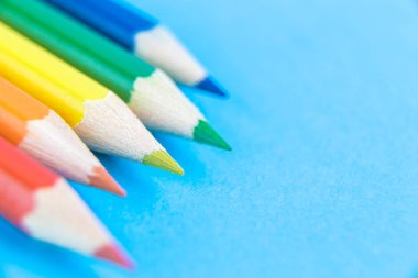 Multicolored wooden pencils on pastel blue.