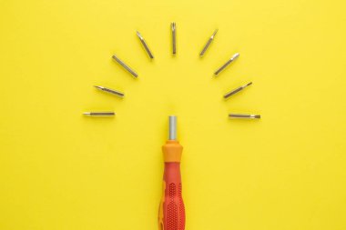 Top view of small screwdrivers set tool kit abstract isolated on yellow.
