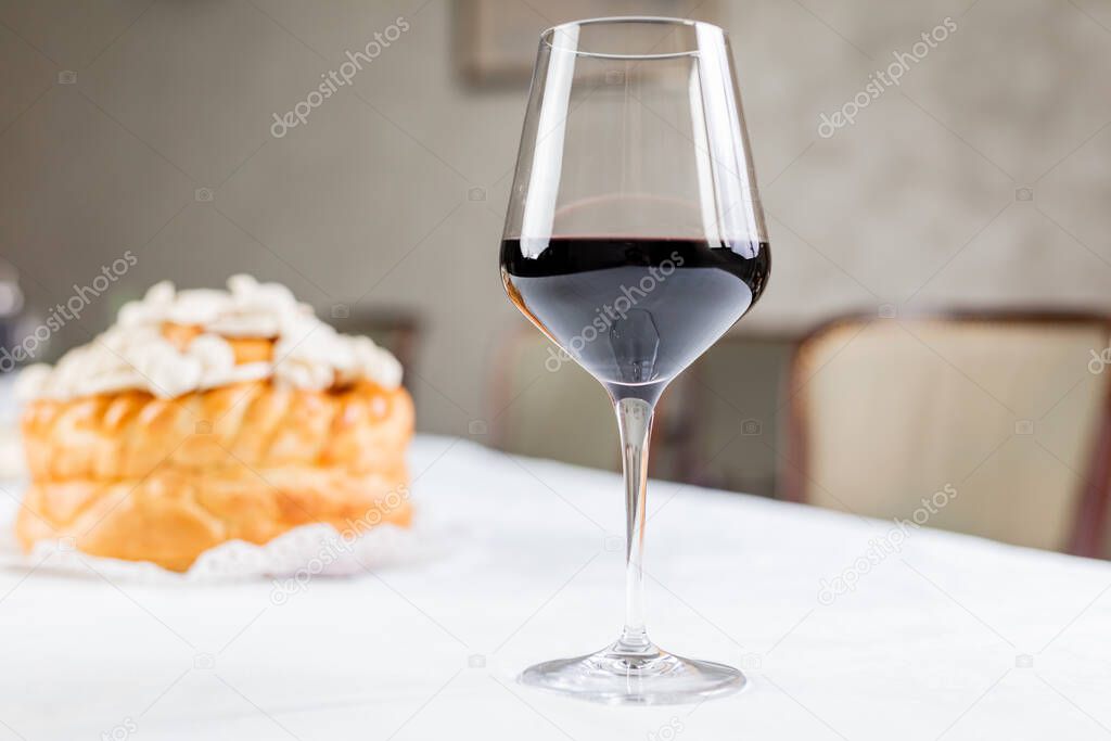 Glass of wine with decorated bread on table for celebration a saint in Orthodox faith. Serbian traditional and cultural heritage.
