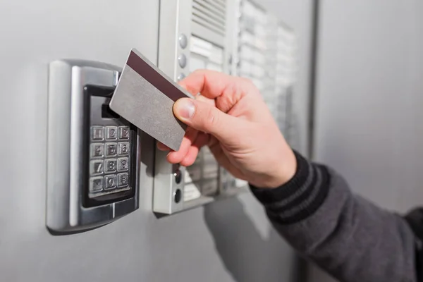 Man skanning säkerhet nyckelkort på elektriska lås för att komma in privat byggnad. — Stockfoto