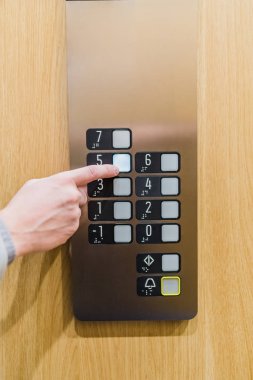 Modern ahşap ve çelik asansörde iş adamının düğmesine bas..