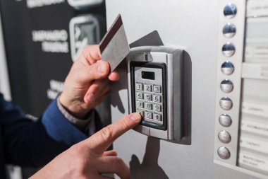 Adam güvenlik şifresini kırıyor ve kapıyı açmak için anahtar kartı kullanıyor.