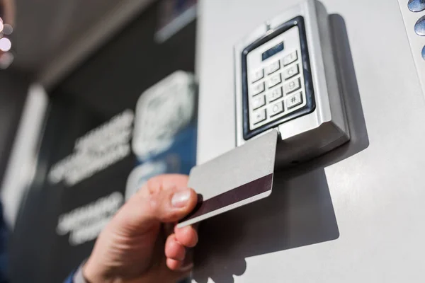 L'homme scanne la carte de sécurité sur la serrure électrique à l'entrée du bâtiment privé . — Photo