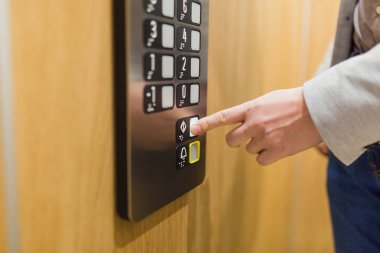 Forefinger asansörde kapı kapatma düğmesine basıyor..