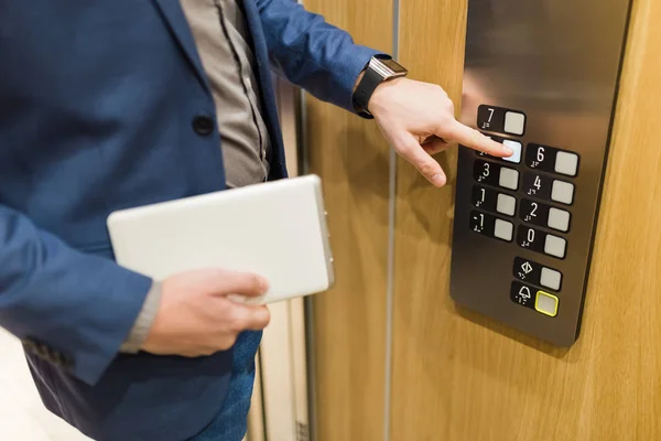 Людина Тримає Цифровий Планшет Під Час Використання Панелі Керування Ліфтом — стокове фото