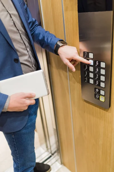 エレベーターボタンを押すタブレットデバイスでビジネスマンの閉鎖 ビジネス オフィスビルミーティングコンセプト — ストック写真