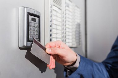 Özel binaya girmek için elektrik kilidinde güvenlik kartını tarayan adam.