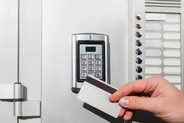 ドアのアクセス制御を閉じる ドアをロックまたはロック解除するキーカードを保持する男の手 — ストック写真