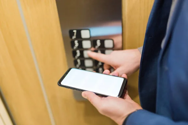 Man Händer Håller Tom Skärm Mobiltelefon När Använder Hiss Kontrollpanelen — Stockfoto