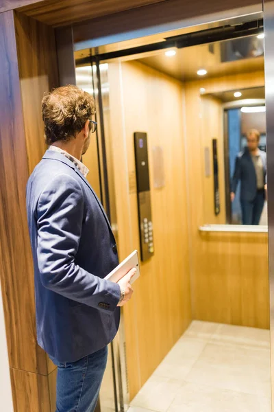 Сучасний Чоловік Тримає Планшетний Пристрій Використовує Ліфт Офісному Будинку — стокове фото