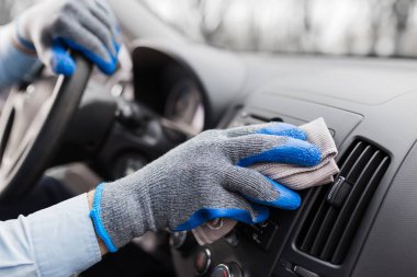 Otomotiv personeli arabanın içini mikrofiber bezle temizliyor. Araba temizleme ve valelik kavramı