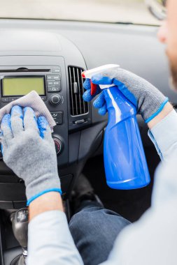 Araba temizleme konsepti. Araba yıkama işçisi dezenfektan ve mikrofiber bez kullanıyor..