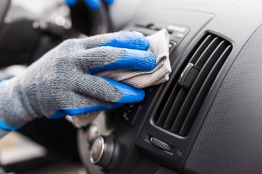 Koruyucu eldiven takan ve arabanın içini mikrofiber bezle temizleyen adamın elini kapat. Araba temizleme ya da valelik kavramı.