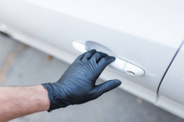 Ellerinde lastik eldivenlerle arabanın kapı kolunu tutuyorlardı..