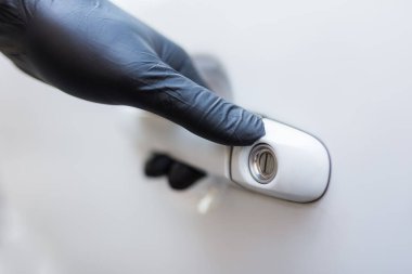 Cerrahi koruyucu eldivenli sürücü arabanın kapısını açıyor. Coronavirus önleme.