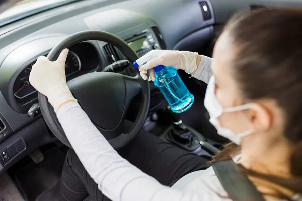 Fahrer Trägt Maske Und Schutzhandschuhe Während Desinfektionsmittel Auf Das Lenkrad — Stockfoto