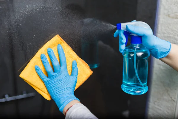 マイクロファイバークロスとスプレー消毒剤でゴム手袋のクリーニングシャワーキャビンガラスの女性の手の閉じる — ストック写真