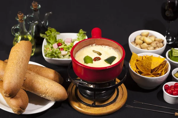 Fondue de xesse com pão e legumes em prato vermelho . — Fotografia de Stock