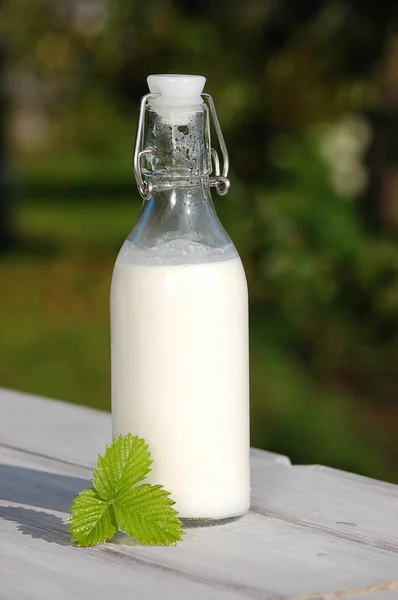 ahşap bir masa üzerinde bir şişe süt