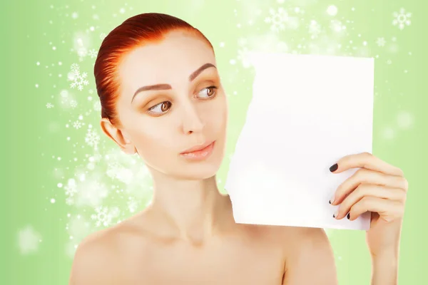 beautiful ginger haired woman watches blank paper