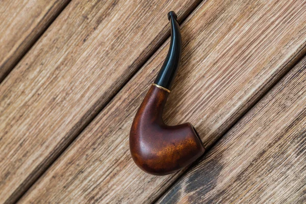 Smoking pipe on a background of old wood