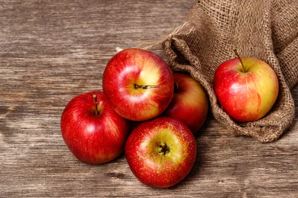 Saftiger roter Apfel auf altem Holzgrund — Stockfoto