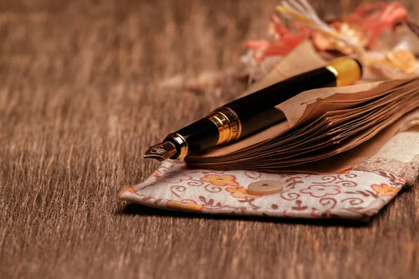 Ahşap arka plan üzerinde tasarımcı defter ve mürekkep kalem