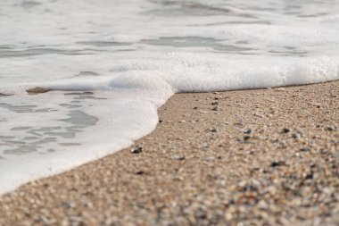 Okyanus dalgası kumlu bir sahilde, gün batımında arka plan kullanımı için.
