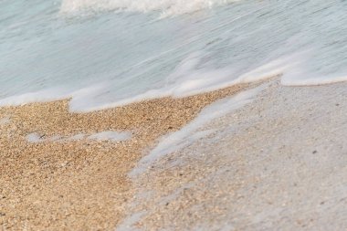 Okyanus dalgası kumlu bir sahilde, gün batımında arka plan kullanımı için.