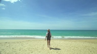 Kumsalda sırt çantalı turist kız.