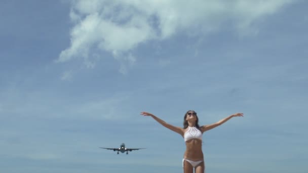 Chica con las manos levantadas con avión de aterrizaje — Vídeos de Stock