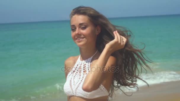 Jeune femme sur une plage jouissant du soleil — Video