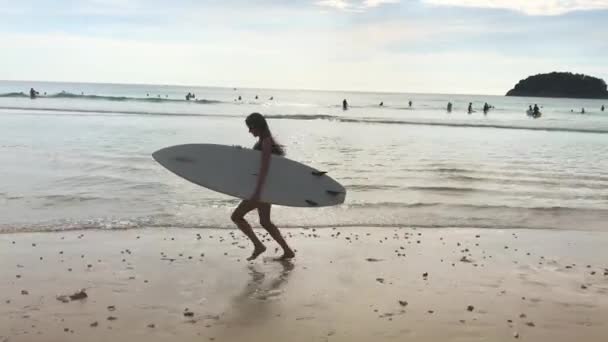 Chica surfista corriendo a lo largo del mar con tabla de surf — Vídeos de Stock