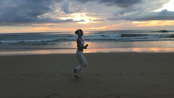 Sportieve vrouw draait op het strand — Stockvideo