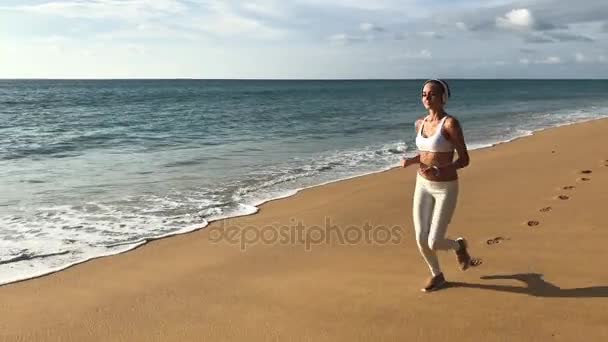 Fitness mujer joven corriendo en la playa — Vídeo de stock