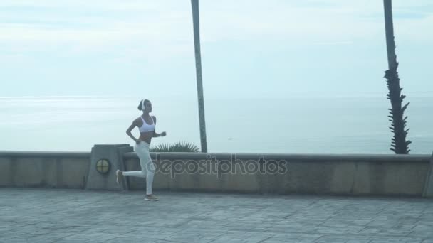 Joven mujer corriendo a lo largo del banquillo — Vídeos de Stock