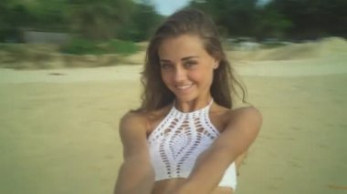 Kumsalda yuvarlak dönen genç kadın