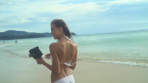 Женщина с винтажной 8-миллиметровой камерой — стоковое видео