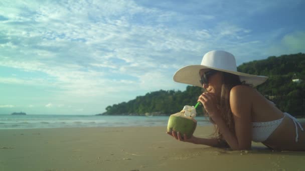 Mujer joven en bikini bebida cóctel en la playa — Vídeos de Stock