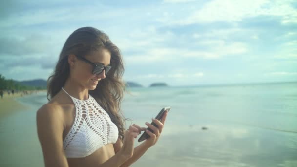 Kobieta za pomocą jej mobilnych Phone.On plaży — Wideo stockowe