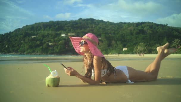 Женщина с помощью смартфона на пляже — стоковое видео