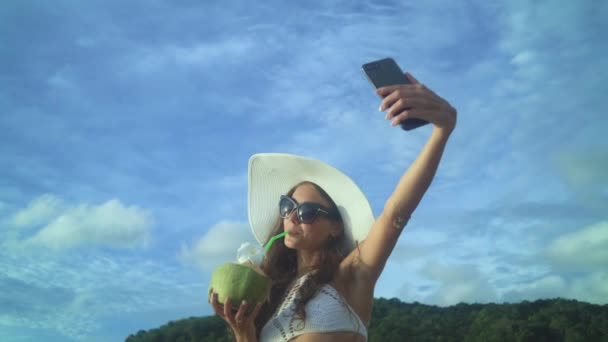 Жінка п'є кокосове молоко під час тропічних канікул — стокове відео