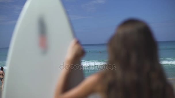 Kvinna som tittar på vatten stående med surfbräda — Stockvideo