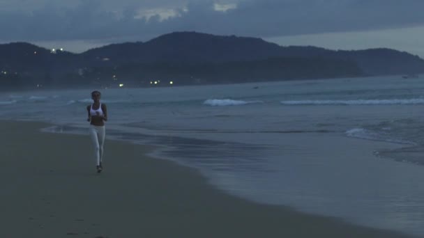 Coureur sportif courant sur la plage au coucher du soleil — Video