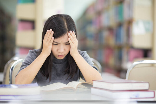 Woman has head ache in the library